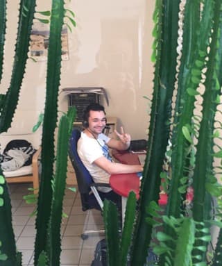 Thomas Gal at around 18, at his desk in his first office behind a row of cacti